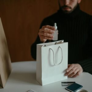 Focused man pulling out beauty product from shopping bag at table